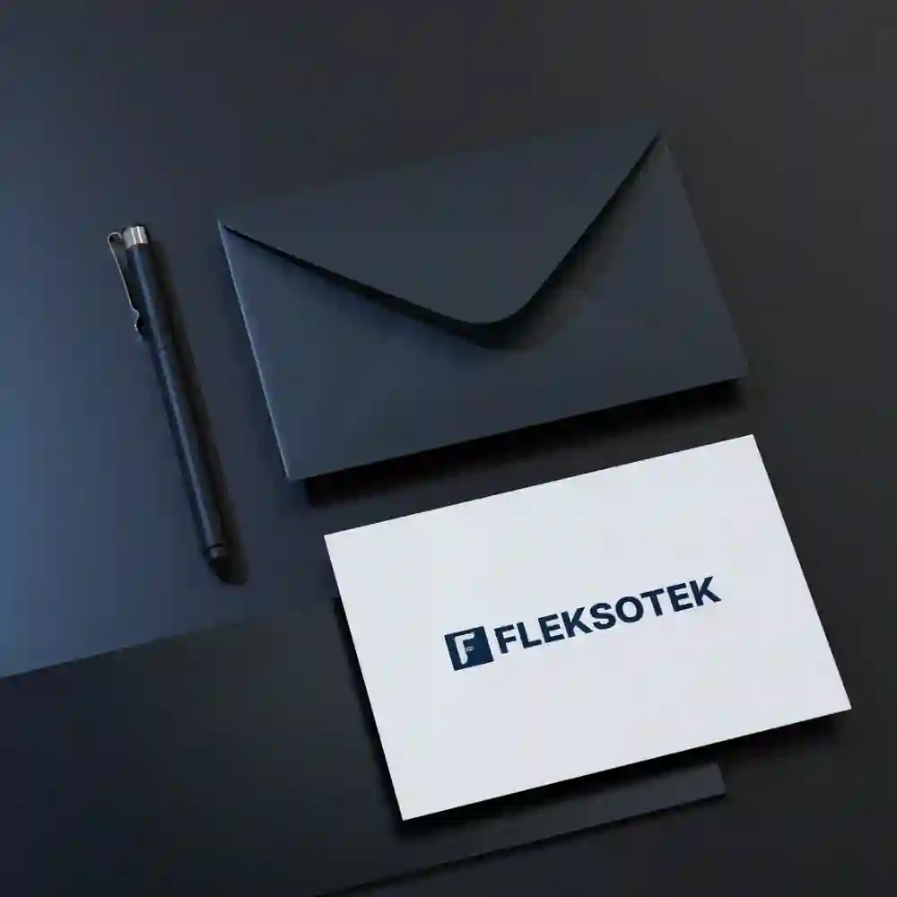 Elegant dark and white envelope set with Flekstek branding, displayed with a pen.